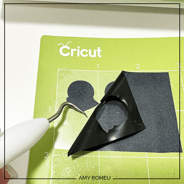 weeding black vinyl on a Cricut cutting mat