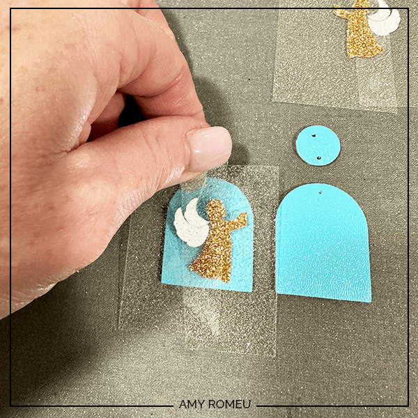 pressing layers of faux leather arched angel earrings with a Cricut