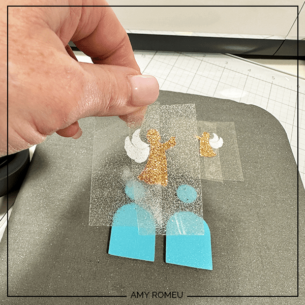 pressing layers of faux leather arched angel earrings with a Cricut