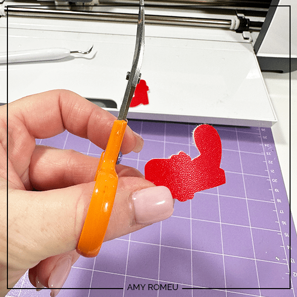 trimming edges of faux leather for Santa Boot Earrings made with a Cricut