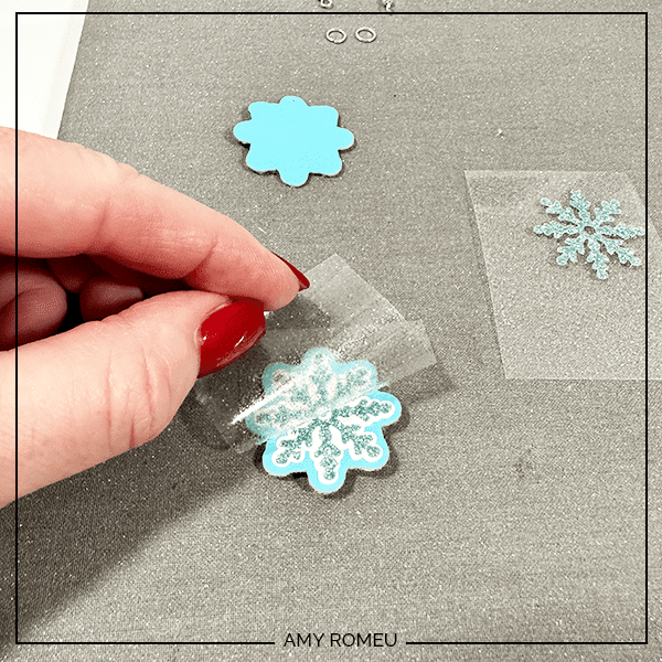 removing vinyl from faux leather snowflake earrings made with a Cricut