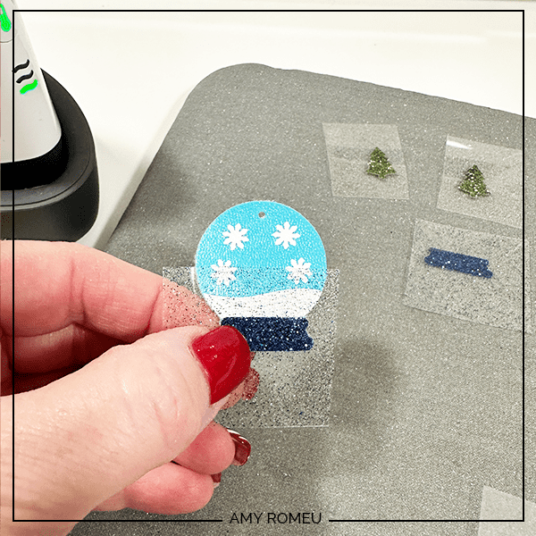 pressing heat transfer vinyl to to make faux leather snow globe earrings with Cricut