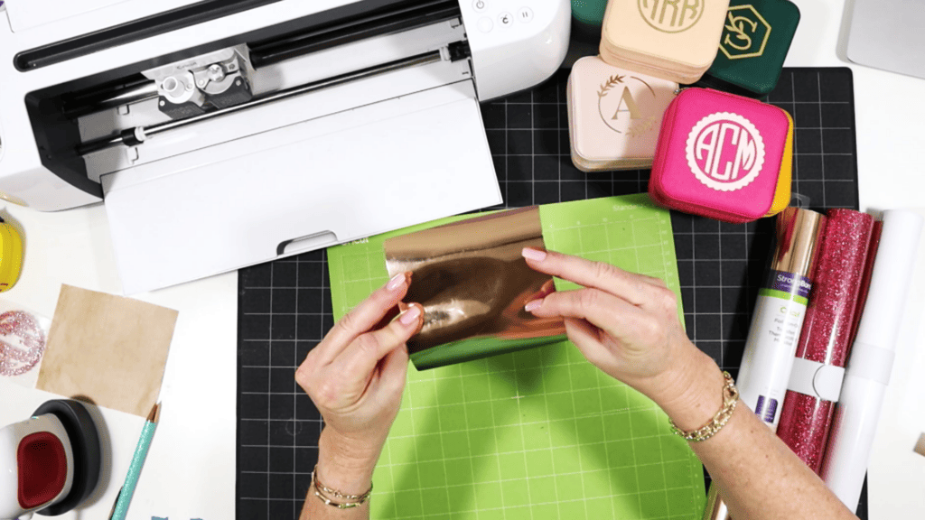 cutting and pressing heat transfer vinyl onto a travel sized jewelry box