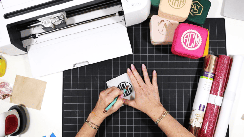 cutting and pressing heat transfer vinyl onto a travel sized jewelry box