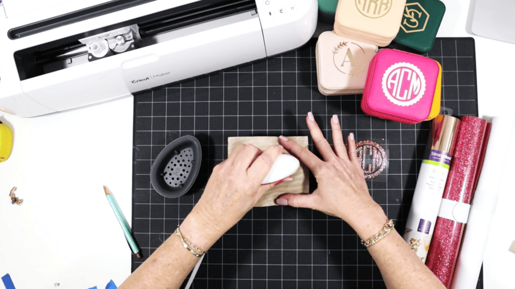 cutting and pressing heat transfer vinyl onto a travel sized jewelry box