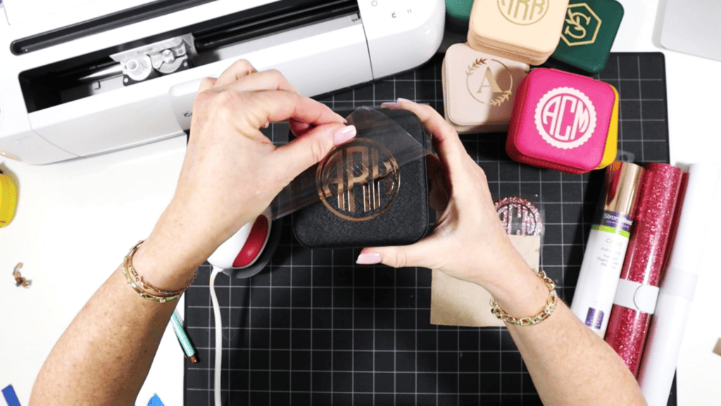 cutting and pressing heat transfer vinyl onto a travel sized jewelry box