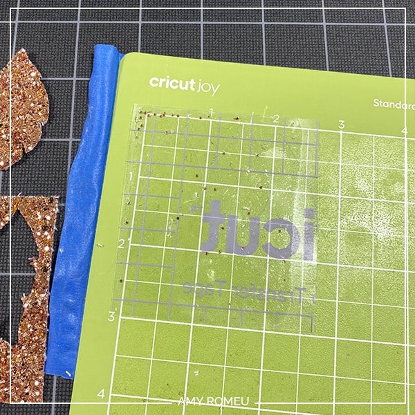 glitter faux leather residue stuck to transfer tape on a Cricut Joy cutting mat