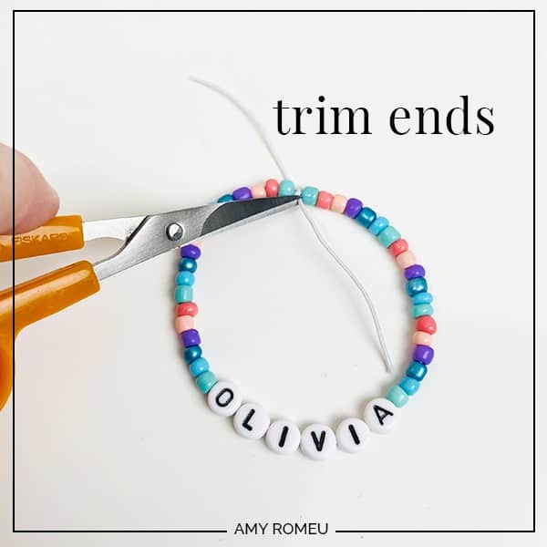 trimming ends of stretchy bracelet with scissors