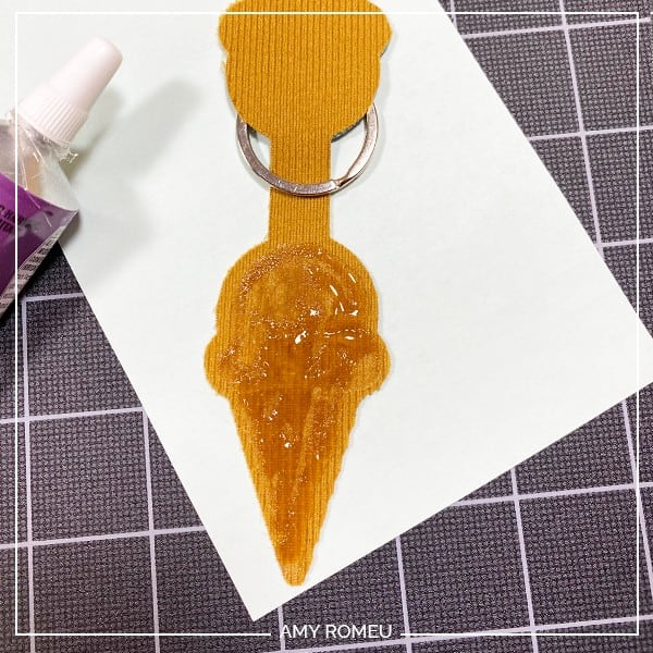applying glue to the back of faux leather Cricut ice cream cone keychain